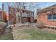 Charming brick residence with a quaint backyard space, including white benches and a small grassy area at 404 S Grant St, Denver, CO 80209