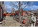 Inviting backyard retreat featuring a stone patio, garden decor, and mature landscaping around the brick structure at 404 S Grant St, Denver, CO 80209