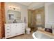 Bright bathroom featuring a soaking tub, glass shower, and a marble vanity with modern fixtures at 404 S Grant St, Denver, CO 80209