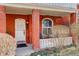 Inviting front porch with red brick columns and a cozy seating area with arched windows at 404 S Grant St, Denver, CO 80209