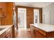 Open kitchen with stainless refrigerator, island, and exposed brick accent wall at 404 S Grant St, Denver, CO 80209