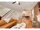 Open-concept living room with hardwood floors, exposed brick, a staircase, and seamless access to the dining area at 404 S Grant St, Denver, CO 80209