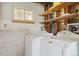 Functional laundry room with washer, dryer, shelving, and window, providing a convenient space for laundry tasks at 219 Douglas Fir Ave, Castle Rock, CO 80104