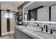 Bathroom with a dual sink vanity, modern lighting, and glass-enclosed shower at 5945 W 86Th Ave, Arvada, CO 80003