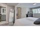 Cozy bedroom with a view into the adjacent bathroom featuring updated fixtures and a full-length mirror at 5945 W 86Th Ave, Arvada, CO 80003