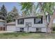 Beautiful exterior view of a white home with black trim and a well-kept lawn at 5945 W 86Th Ave, Arvada, CO 80003