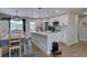 Open kitchen with a central island, dining area, and white cabinetry at 5945 W 86Th Ave, Arvada, CO 80003