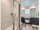 A bright bathroom with a glass-enclosed shower, double sinks, and a vanity area with plenty of natural light at 14551 Hudson St, Thornton, CO 80602