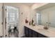 Bright bathroom featuring dual sinks, a large mirror, and a separate toilet and shower room at 14551 Hudson St, Thornton, CO 80602