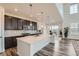 Bright and open kitchen with large island, dark cabinets, and stainless appliances at 14551 Hudson St, Thornton, CO 80602