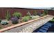 Professionally designed backyard featuring a retaining wall, vibrant plants, and decorative rock at 14551 Hudson St, Thornton, CO 80602