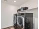 Modern laundry room with new washer and dryer set and shelving for storage at 14551 Hudson St, Thornton, CO 80602