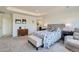 A luxurious main bedroom boasts a tufted headboard, cozy seating area, and ample natural light for a serene retreat at 14551 Hudson St, Thornton, CO 80602