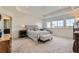 A luxurious main bedroom boasts a tufted headboard, cozy seating area, and ample natural light for a serene retreat at 14551 Hudson St, Thornton, CO 80602