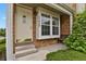 Inviting front porch with brick accents, a cozy bench, and a well-lit entrance at 14396 E Temple Pl # D, Aurora, CO 80015