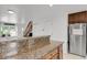Bright kitchen features a breakfast bar, stainless steel appliances, and access to the staircase at 14396 E Temple Pl # D, Aurora, CO 80015