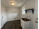 A well-lit laundry room with vinyl floors, a stainless steel sink, and storage cabinet at 4670 Independence St, Wheat Ridge, CO 80033
