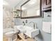 Modern bathroom featuring marble-tiled shower, floating shelves, and vessel sink with updated fixtures at 25 Kendall St, Lakewood, CO 80226