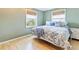 Bright bedroom with hardwood floors, two sunny windows and stylish, patterned bedding at 25 Kendall St, Lakewood, CO 80226