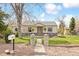 Charming single-story home with stone accents, a walkway and a well-manicured lawn at 25 Kendall St, Lakewood, CO 80226