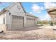 Two-car garage with stone accents, craftsman garage doors, and additional outdoor storage at 25 Kendall St, Lakewood, CO 80226