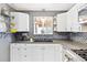 Well-equipped kitchen featuring white cabinetry, dark countertops, and modern appliances at 25 Kendall St, Lakewood, CO 80226