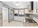 Updated kitchen with white cabinetry, stainless steel appliances, and a cozy breakfast nook at 25 Kendall St, Lakewood, CO 80226
