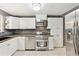 Modern kitchen with stainless steel appliances, white cabinets, and sleek countertops at 25 Kendall St, Lakewood, CO 80226