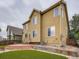 Exterior view of home featuring a red brick patio, artificial turf, and fenced yard at 5553 Jasper St, Denver, CO 80239