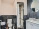 Bathroom features a shower with patterned tile, white vanity and gray painted walls at 5553 Jasper St, Denver, CO 80239
