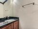 Bathroom featuring a black granite countertop with a sink, mirror, and towel rack at 5553 Jasper St, Denver, CO 80239