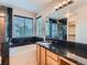 Bathroom featuring a vanity with a black countertop, soaking tub, and a walk-in shower at 5553 Jasper St, Denver, CO 80239
