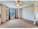 Bedroom with a vaulted ceiling, ceiling fan, and a large window with shelving at 5553 Jasper St, Denver, CO 80239