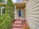 Charming home entrance with brick steps, blue door, and decorative plants at 5553 Jasper St, Denver, CO 80239