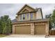 Two car garage with stone accents, neutral doors and dark roof at 5553 Jasper St, Denver, CO 80239