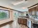 Kitchen with wood floors, stainless steel appliances, island with bar seating, bright window at 5553 Jasper St, Denver, CO 80239