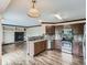 Open concept kitchen with stainless steel appliances, island and adjacent living room at 5553 Jasper St, Denver, CO 80239