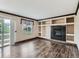 Living room with sliding door, built-in shelves, fireplace, and wood floors at 5553 Jasper St, Denver, CO 80239