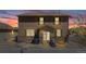 Two-story house featuring stone accents, a small patio and lawn, and a dusk sky at 2177 Shadow Creek Dr, Castle Rock, CO 80104