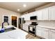 Modern kitchen boasts white cabinets, subway tile backsplash, stainless steel appliances, and stylish countertops at 2177 Shadow Creek Dr, Castle Rock, CO 80104