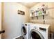 Convenient laundry room with front loading washer and dryer plus shelving for storage at 2177 Shadow Creek Dr, Castle Rock, CO 80104
