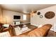 Inviting living room features a brown leather sofa, coffee table, media cabinet, and stylish decor at 2177 Shadow Creek Dr, Castle Rock, CO 80104