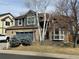 View of a two-story home with brick and blue siding, featuring a two-car garage and well-manicured landscaping at 1618 Garnet St, Broomfield, CO 80020