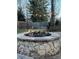 Outdoor stone fire pit is surrounded by pavers and string lighting creating an inviting backyard space at 1618 Garnet St, Broomfield, CO 80020