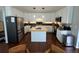 Modern kitchen featuring white cabinets, stainless steel appliances, an island, and hardwood flooring at 1618 Garnet St, Broomfield, CO 80020