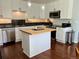 Well-lit kitchen boasting white cabinets, stainless steel appliances, and a butcher block island perfect for meal prep at 1618 Garnet St, Broomfield, CO 80020