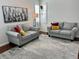 Bright living room featuring cozy gray sofas, decorative pillows, hardwood floors and a stylish area rug at 1618 Garnet St, Broomfield, CO 80020