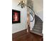 Elegant curved staircase featuring carpeted steps, a white railing, and a glimpse of the hardwood entry at 1618 Garnet St, Broomfield, CO 80020