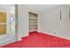 Bedroom with shelving, closet, and red carpet at 8259 Nola Dr, Denver, CO 80221