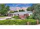 Well-maintained brick home with lush landscaping, featuring a manicured lawn and mature shrubs at 8259 Nola Dr, Denver, CO 80221